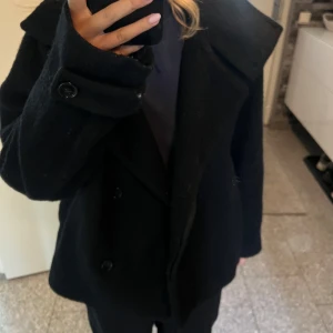 Arket kappa  - Säljer min snygga svarta kappa från arket. Den är i bra skick men har ett hål på insidan men det syns inte när man har den på sig.