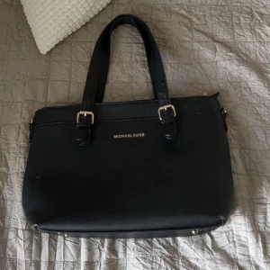 Väska  - En Michael kors väska, vet inte om den är riktigt och därför den säljs billigt💕 den är perfekt nu till skolan. Den har en liten fläck (bild 4) men går att tvättas bort. Sen är den lite sliten längst ner (bild 5). Skriv för fler frågor💕pris kan diskut