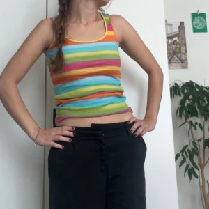 Flerfärgad randig linne - Säljer en superfin flerfärgad randig linne i storlek S. Linnet har en tight passform och är perfekt för sommaren. Det är ärmlöst och har en croppad stil som gör det extra trendigt. Materialet känns mjukt och bekvämt mot huden.