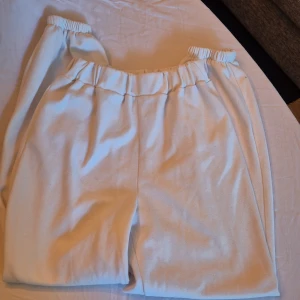 Vita mjukisbyxor - Säljer ett par supermysiga vita mjukisbyxor. De är högmidjade med en elastisk midja för extra komfort. Perfekta för en chill dag hemma eller en avslappnad promenad. Materialet känns mjukt och skönt mot huden. Passar perfekt till höst- och vintermys!