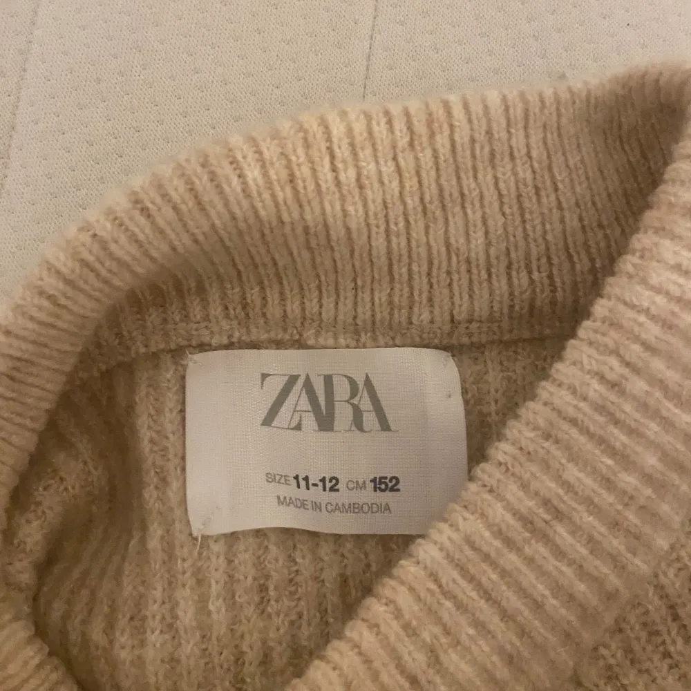 Säljer en supermysig beige stickad tröja från Zara. Den är i storlek 152 (11-12 år) och är perfekt för höst och vinter. Tröjan har en normal passform och är långärmad med en ribbad struktur. Perfekt för att hålla sig varm och snygg under de kallare månaderna! 💛. Tröjor & Koftor.