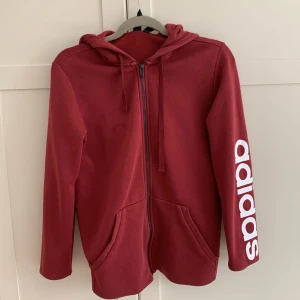 Vinröd adidashoodie  - Hoodie som har använts mycket men säljer då den inte är min stil längre. Är i storlek L men skulle säga att den passar som M