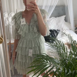 By Malina klänning  - Sky v-neck frill mini lace dress i färgen pistachio. Köpt på boozt.com. Använd endast 1 gång på ett bröllop förra sommaren. Med andra ord i väldigt gott skick men inga prislappar kvar. Passar mig bra som vanligtvis har storlek S. Nypris 2800 💛