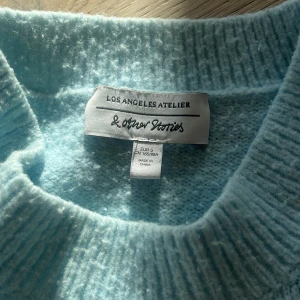 Ljusblå stickad tröja från & Other Stories - Säljer en superfin ljusblå stickad tröja från & Other Stories. Den är i storlek S och är perfekt för höst och vinter. Tröjan har långa ärmar och en normal passform. Den är riktigt mysig och varm, perfekt för kyliga dagar. Köp den nu och håll dig varm och snygg! 💙