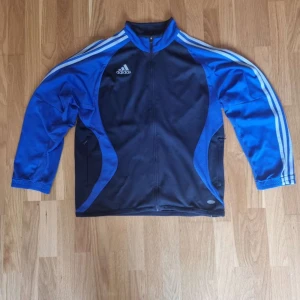 Adidas kofta blå/svart - Nyköpt kofta som tyvärr ej kommit till använding alls då den är för stor för mig, mycket bra skick.  