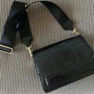 Crossover väska nyskick - Helt ny crossover väska, använd max 2 ggr. Från NA-KD 🤍 Med fina gulddetaljer och många rymliga  fack. Dn musthave!! Nypris: 549kr Mitt pris: 150kr