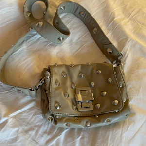 Beige axelväska från Sonia Rykiel - Säljer en superfin äkta Sonia Rykiel väska med nitar och leopardmönster inuti!💕Har endast använt den en gång och säljer på grund av att den inte riktigt passar min stil💘