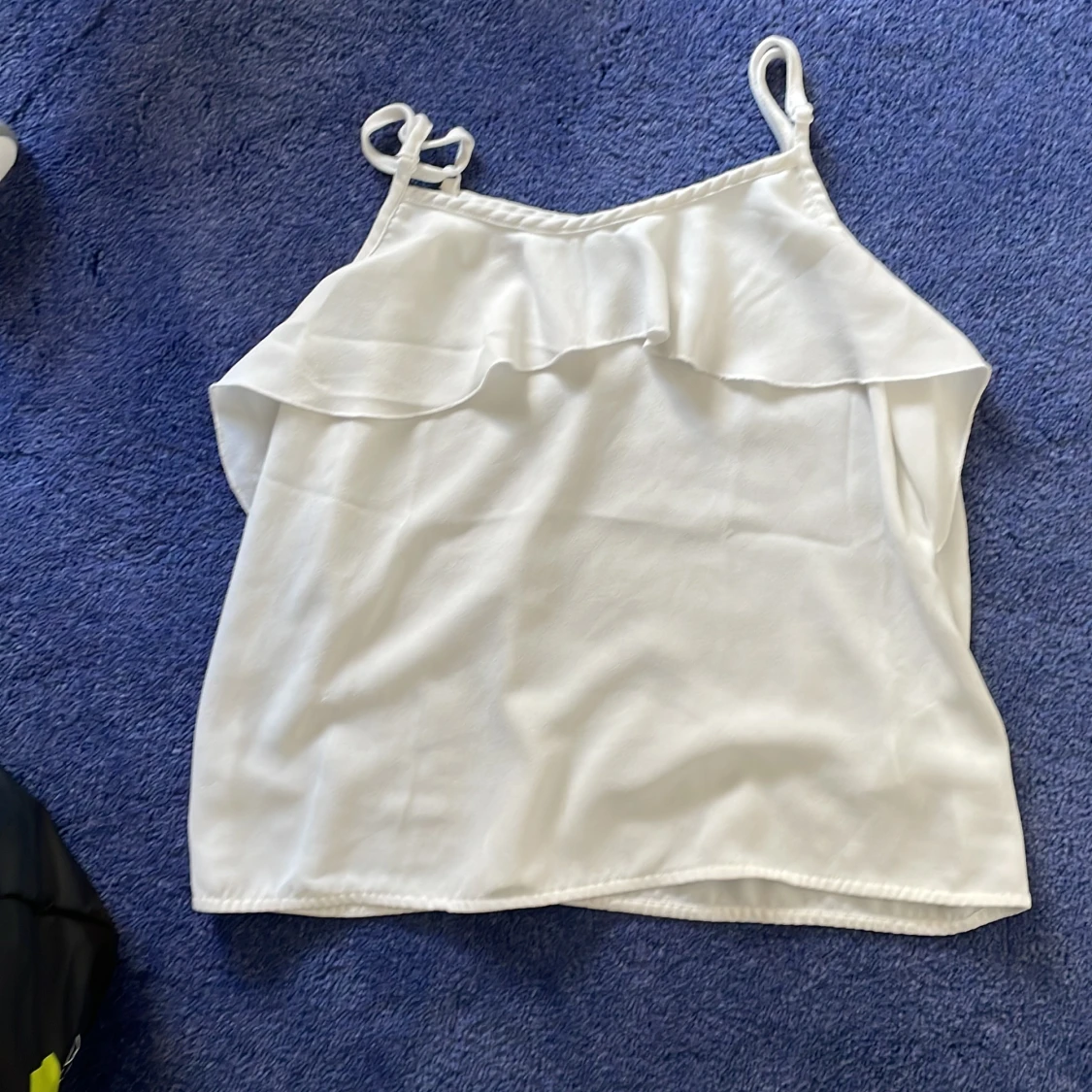 Vit ärmlös topp med volangdetalj