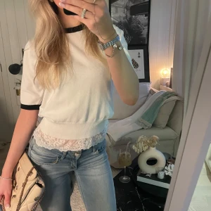 Vit kortärmad topp - Snygg vit topp med svarta kanter. Perfekt för en stilren look. Kortärmad design med en bekväm passform. Trekvartsärmad.