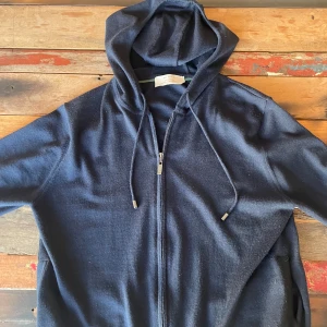 Mörkblå hoodie från Pal Zileri - Snygg och bekväm mörkblå hoodie från Pal Zileri's Effortless Capsule Collection. Väldigt exklusivt italienskt märke som knappt finns i Sverige. Köptes förra året på Harrods i London för 350£, vilket motsvarar ungefär 4900 kr. Storlek 48 vilket passar M perfekt. 