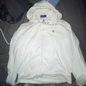 Vit hoodie från Polo Ralph Lauren - Säljer en vit zip hoodie från Polo Ralph Lauren, säljer för att den inte passar mig så bra och jag använder den inte. Finns ett yterst litet hål men det är inte större än en ärta så man märker det inte. Om du har något kul att byta går det också bra