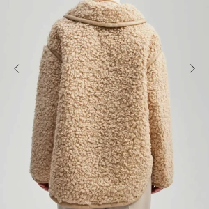 Beige teddyjacka med dragkedja - Mysig beige teddyjacka med dragkedja och stora fickor framtill. Perfekt för kyliga dagar med sin fluffiga och varma design. Orginalpris 4500 kr. 