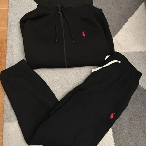 Kofta och byxor från Ralph Lauren - Säljer en svart hoodie och matchande byxor från Ralph Lauren. De är i perfekt skick och säljer de pga behov av pengar. Perfekt för en avslappnad stil. Både byxorna och koftan är i strl M.
