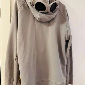 CP Company zip up hoodie - Säljer en grå hoodie från C.P. Company pgd använder inte längre. Har en gömd fläck som är enkel att ta bort. Ord Pris: cirka 3000kr. Pris kan diskuteras