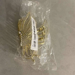 Guldglittriga örhängen - Snygga guldglittriga örhängen med strassdetaljer. Perfekta för att ge en extra touch av glamour till din outfit. De har en elegant design som passar till festliga tillfällen.