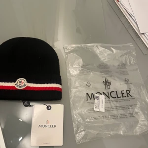 Moncler mössa - Gillar inte hur den sitter på mig därför säljer jag den, dustbag ingår och qr koden funkar 
