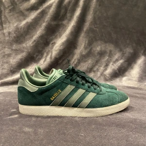 Adidas Gazelle skor grön  - Skohylla rensning! •Adidas Gazelle mörkgröna i mocka. Skick: 8-9/10, mycket fint skick! Storlek: 40 2/3, skulle säga det sitter som en storlek 40-41:) Hör av dig vid frågor eller funderingar, mvh Oliver;)