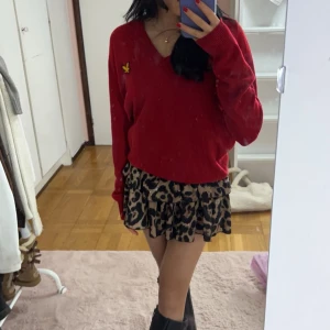 Lyle & skott stickad tröja - Snygg röd tröja med v-ringning från lyle& skott . Perfekt för en stilren look. Passar bra till både kjol och byxor.