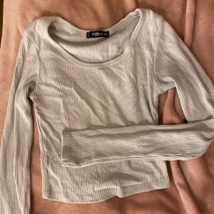 Vit långärmad tröja - Vit långärmad tröja med en u-ringning🤍Den är i ett ribbat material & normal i längden. Använd ett par gånger & har knotter under armarna, därav priset! Säljer den då den inte kommer till användning längre🤍