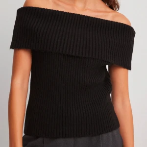 Svart ribbad offshoulder topp - Stickad offshoulder topp från NAKD. I väldigt bra skick men kommer tyvärr inte till användning. Storlek Xs💕