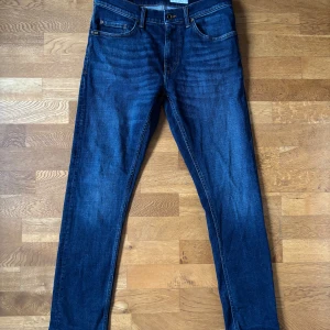 Blå jeans från Tiger of Sweden - Snygga blå jeans från Tiger of Sweden i modellen Pistolero. De har en klassisk femficksdesign och är tillverkade i ett slitstarkt material | 31 32 | Helt oanvända |