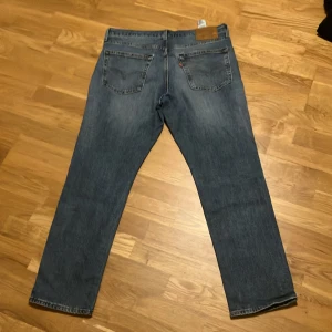 Levi's 511 jeans - Snygga Levi's 511 jeans i en klassisk blå färg. De har en normal passform och är tillverkade i slitstarkt denim. Perfekta för en avslappnad stil med fem fickor och knappgylf.modell:511.storlek w36 L30