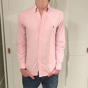 Rosa  Ralph Lauren skjorta - Rosa skjorta från Ralph Lauren. Skjortan har inga defekter. Size (XS slimfit) men lutar mer åt S. Modellen är 177cm. Hör av dig vid funderingar!