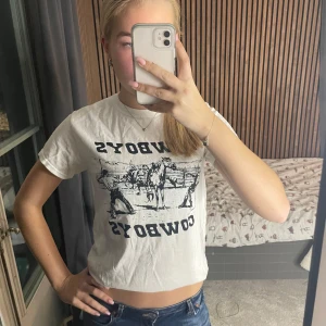 Vit t-shirt med cowboy-tryck - Snygg vit t-shirt med ett coolt cowboy-tryck i svart. 