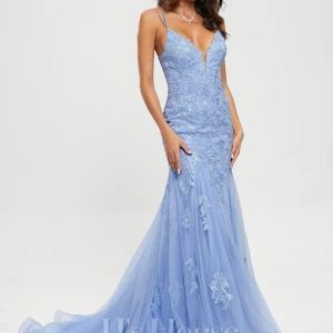 Ljusblå långklänning med spetsdetaljer - Elegant ljusblå långklänning med smala axelband och djup v-ringning. Klänningen har vackra spetsdetaljer och en snörning i ryggen som ger en perfekt passform. Perfekt för bal eller festliga tillfällen. Använd en bal. Släpet är bortsytt av skräddare. Storlek 34