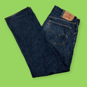 Levi's 501 Jeans - Säljer ett par klassiska Levi's 501 jeans i mörkblå denim. De har en rak passform och är tillverkade i 100% bomull. Perfekta för både vardag och fest! 🕺strl w38 L32! Mitt pris 219, fråga/hör av dig om du undrar något! Finns fler bilder!!👖