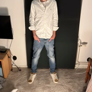 Vit långärmad skjorta polo Ralph Lauren - Säljer en stilren vit långärmad skjorta med knappar. Perfekt för en klassisk look från Polen Lauren.