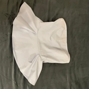 Blå axelbandslös topp - Snygg blå axelbandslös topp med en stilren design. Perfekt för en elegant look. Toppen har en enkel och klassisk stil som passar till många olika outfits.