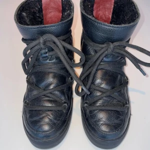 Svarta boots från INUIKII - Snygga svarta boots från INUIKII med snörning och en robust design. Skorna har en hög krage och är tillverkade i skinn med en mjuk insida för extra komfort. Perfekta för kyligare dagar.