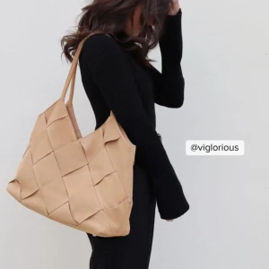 Beige axelväska i mocka - Snygg beige axelväska i mocka med ett jättefint flätat mönster. Väskan har långa handtag och en praktisk innerficka med knappstängning. Perfekt  till vardags! Använd 1 gång🤍🤍Nypris 500kr!