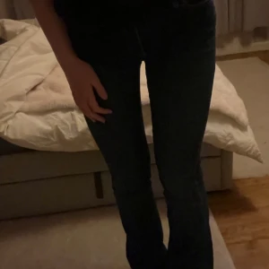 Bootcut Mörkblå jeans från Scalpers - Snygga mörkblå jeans från Scalpers med klassisk femficksdesign och en liten dödskallebroderi på bakfickan. Jeansen har en knapp och dragkedja framtill och är perfekta för en stilren look. Kan diskutera priset! 