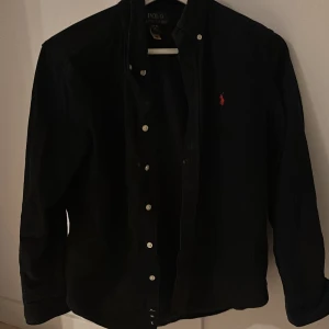 Svart skjorta från Ralph Lauren - Tjena säljer den fräscha Ralph lauren skjortan i manshester material som passar perfekt till alla årstider den är i nyskick och har inga defekter storleken är 165-170 eller Large för barn nypris 1200 mitt pris 350