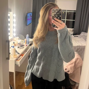 Stickad tröja - Mysig ljusblå stickad tröja med ett fint kabelstickat mönster. Tröjan har långa ärmar och en bekväm passform, perfekt för kyligare dagar.