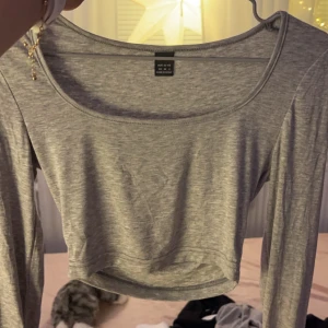 Grå croppad topp från Shein - Säljer en stilren grå croppad topp från Shein. Toppen har en rund halsringning och är tillverkad i ett mjukt material som ger en bekväm passform. Perfekt för en avslappnad look. Har denna tröjan i 3 färger, grå, vit, svart och alla är i samma storlek. 50kr/st eller alla för 130kr