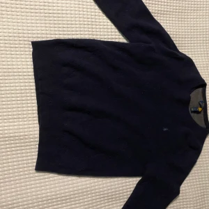 Mörkblå tröja från Polo Ralph Lauren - Säljer en stilren mörkblå tröja från Polo Ralph Lauren. Tröjan har en klassisk design med långärmade ärmar och en liten broderad logotyp på bröstet. Perfekt för en avslappnad men ändå elegant look. Storlek M men passar även Small