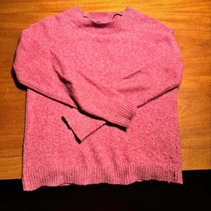 Rosa stickad tröja från Vero Moda - Mysig rosa stickad tröja från Vero Moda. Tröjan har långa ärmar och ribbade muddar vid ärmslut och nederkant. Perfekt för kyliga dagar. 💖Skriv gärna för fler bilder och detaljer🌸🌸