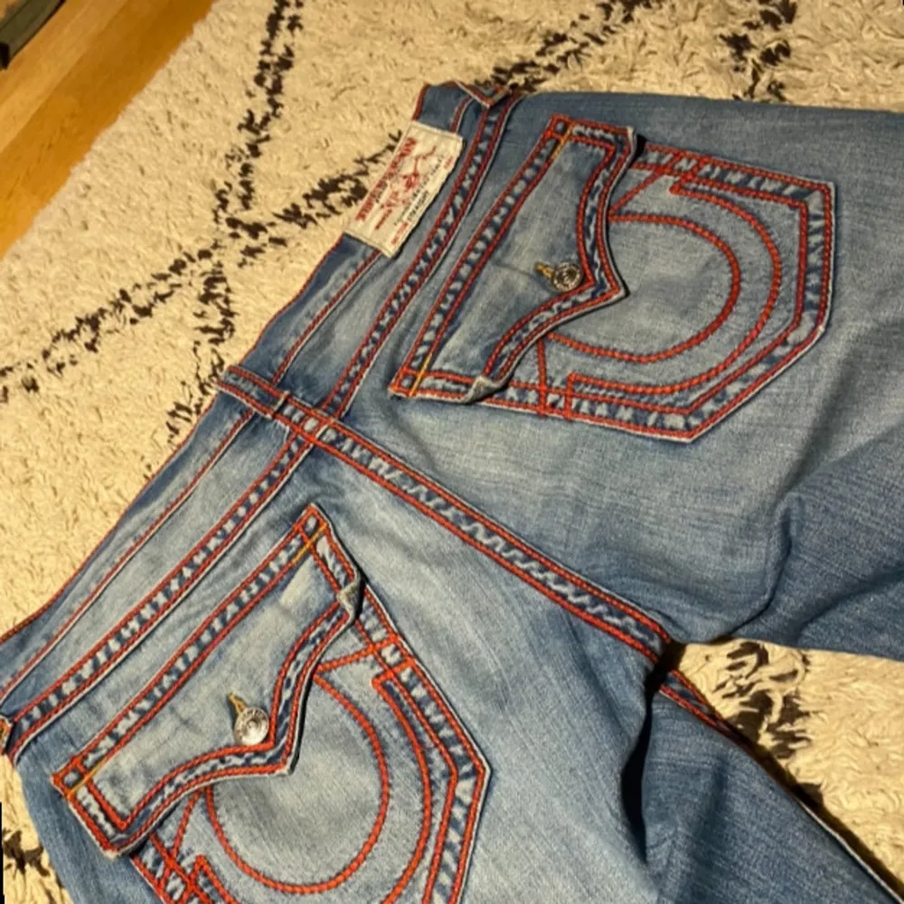 .Hej säljer tvär feta true religion byxor som är i bra skick. Just dessa true religion är väldigt sällsynta och har en väldigt unik röd söm. Säljer dessa pågrund av att dem va lite för långa för mig men dem är sjukt bekväma och sitter väldigt bra annars Mått : Totallängd 110 cm Innerbenslängd 81 cm Midja 48 cm Hör av er ifall ni har frågor!. Farkut & Housut.