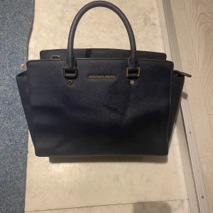 Mörkblå michael kors väska - 34cm lång , jätte fin färg, får plats med skolmaterial, kan diskutera pris 