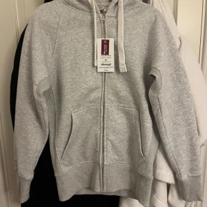 Ljusgrå hoodie med dragkedja - En helt ny zip hoodie från Russemerch i storlek S med prislappen kvar. Aldrig använd! Nypris 750kr .