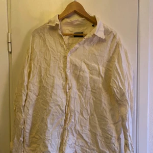 Vit långärmad skjorta Hugo boss - Säljer en stilren vit långärmad skjorta med knappar framtill. Perfekt för en avslappnad look. Skjortan har en klassisk krage och är tillverkad i ett lätt material.