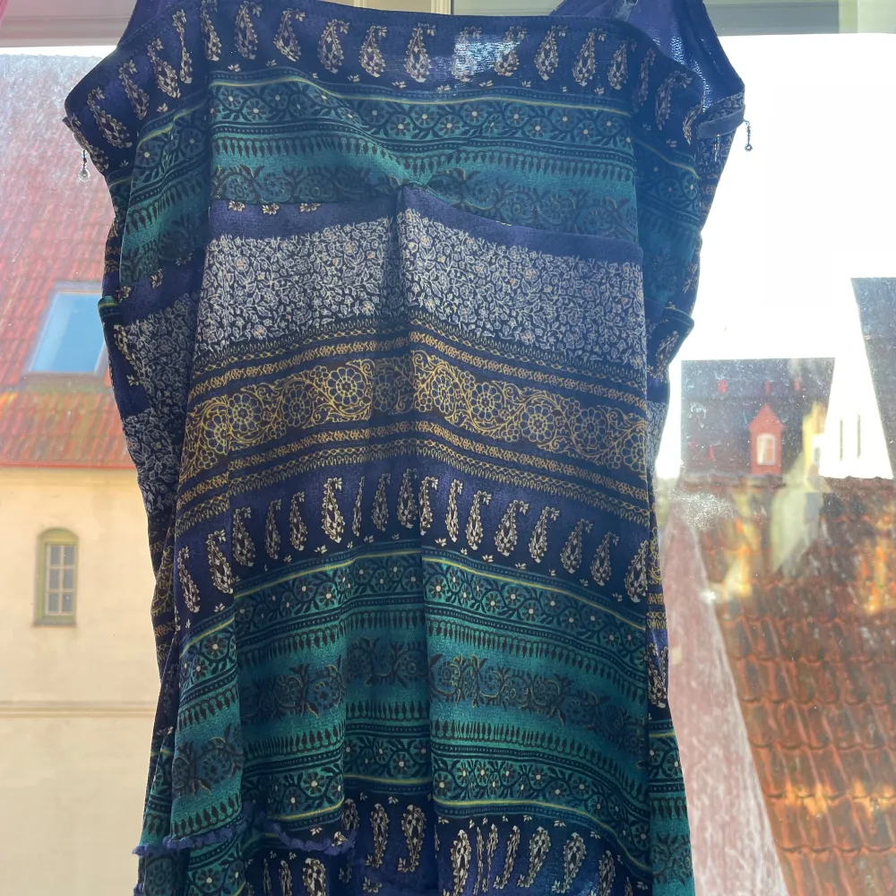Säljer en jättefin ”vintage” blus från Lindex med ett unikt mönster. Påminner om 2000 - talet. Klänningen har en v-ringad design med dekorativa paljetter framtill. Perfekt för dig som vill sticka ut med stil i sommar!! Den va nämligen min mammas gammla som hon använde som klänning, därför är den i storlek L, så jag har sytt in den till strlk S/XS så den sitter bättre i passform. De går hur bra som helst att sprätta upp den, då jag ej har klippt av resterande tyg🤗 Hör av vid intresse!!❤️. Puserot.