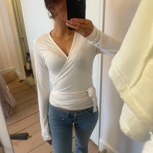 Vit omlottopp från lager 157 - Säljer en stilren vit omlottopp från lager 157. I princip oanvänd och kommer inte till användning för mig. I ny skick och super fin och söt.