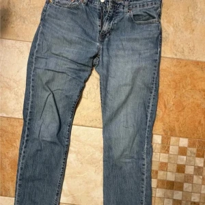 Blå jeans från Levi's 502 - Säljer ett par klassiska blå jeans från Levi's. De har en straight passform och är tillverkade i slitstarkt denim. Perfekta för en avslappnad stil. Levi's-loggan syns tydligt på bakfickan. Storlek W30 L32