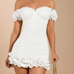 Vit offshoulder klänning med volang - Sååå söt vit offshoulder klänning med volangdetaljer. Perfekt för sommaren och studenten. Aldrig använd! Nypris 300 kr