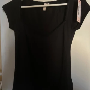 Svart Romance Shape Top från Nelly - Säljer en svart Romance Shape Top från Nelly. Den här prislappen kvar och är helt oanvänd.