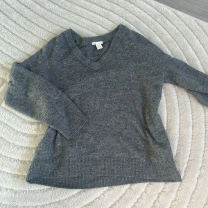 Mörkgrå stickad - Mörkgrå stickad tröja från H&M som är använd men i väldigt bra skick. Med fin V-ringning 🩶